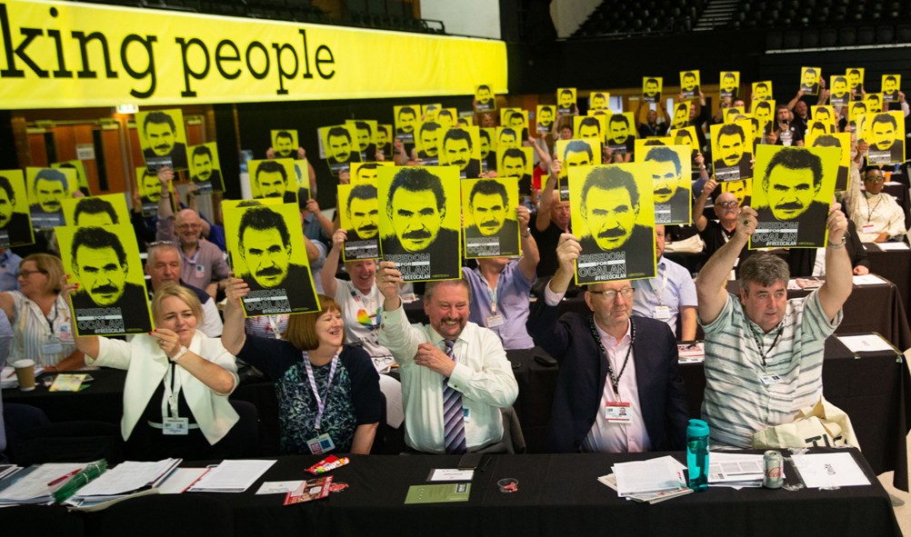 a wide shot of delegates holding Freedom for Ocalan placards at TUC 2019